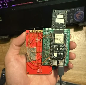 The prototype: an ESP32-S3 module on a perfboard, wired to a red ILI9341 display board, held in a hand
