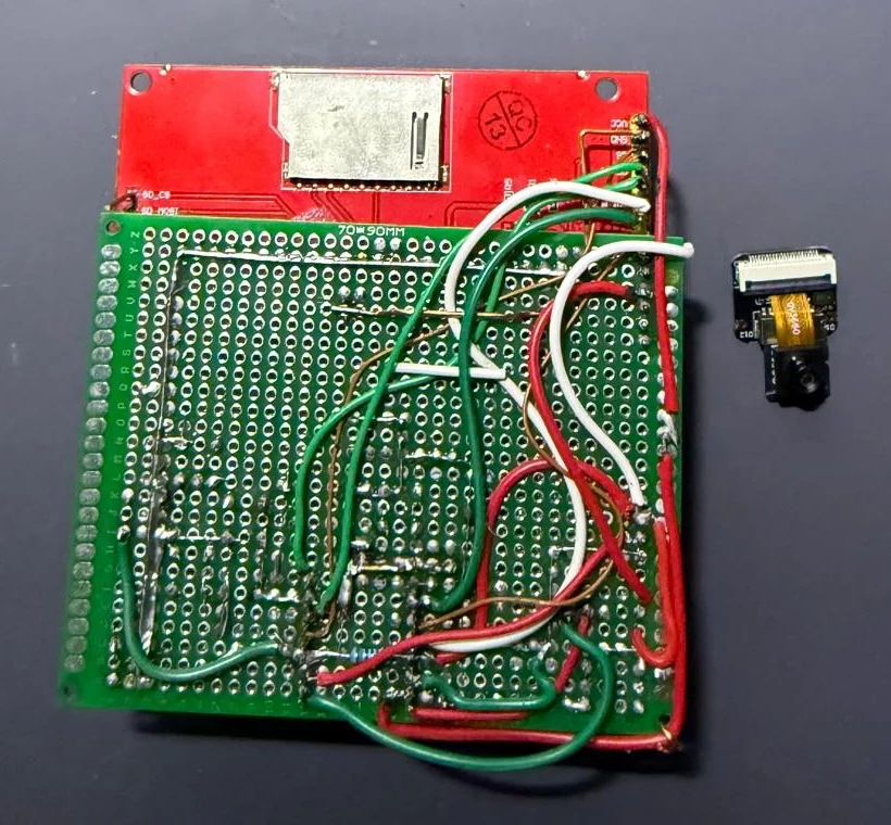 The back of the handheld: point-to-point wiring on the perfboard and the panel's own SD slot (unused). The XIAO's camera module, removed, sits beside it